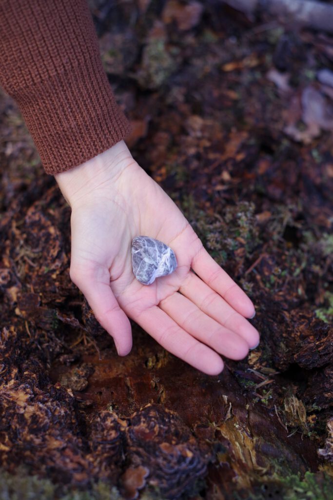 Een hand met een steen in de vorm van een hart. Leer luisteren vanuit je hart.